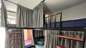 A bunk bed room with grey curtains, wooden slats, and a view of the outside. - ALPHA Hostel Cafe&Bar (Krabi)