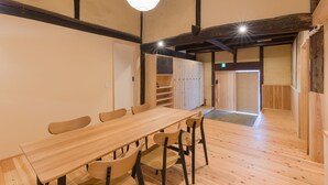 A wooden dining area with a long table and chairs, a ceiling light, and a door leading to another room. - [Rent the whole traditional house] Fukuoka "Goen"  up to 10 people!! (うきは市)