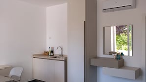 A modern, minimalist bathroom with a built-in sink, a mirror, and a window. - Nautika Suites  (Alghero)