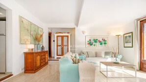 Un salon spacieux avec un canapé bleu clair, un meuble en bois, une table basse et une carte accrochée au mur.