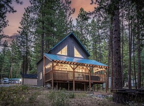 A cabin with a wooden deck, a metal roof, and a large window. - Newly owned Cabin w/ private hot tub, A/C & covered deck - Dog Friendly! (Leavenworth)