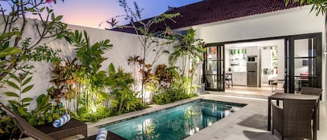 Una piscina al aire libre, tumbonas