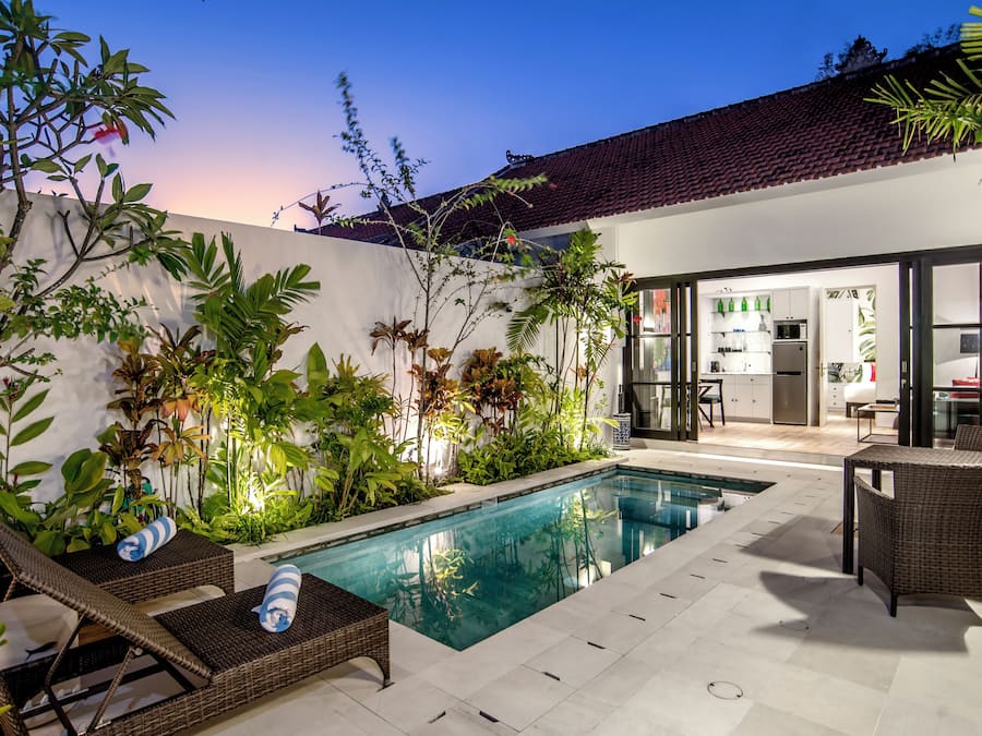 Una piscina al aire libre, sillones reclinables de piscina