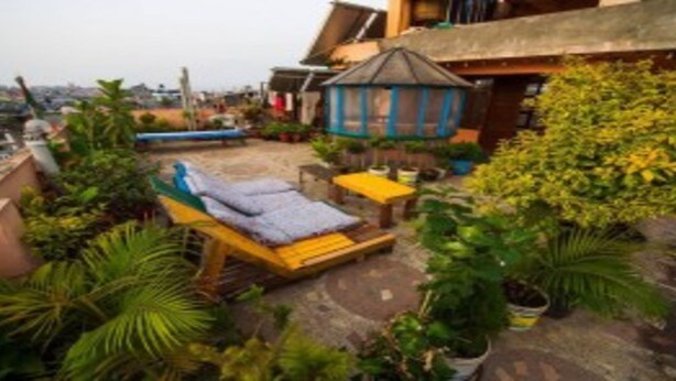 A rooftop garden with a sun lounger, a small gazebo, and potted plants. - MeroStay 180 Hotel EMO (Kathmandu)