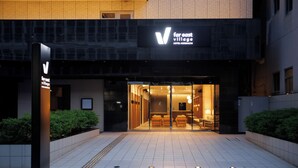 La entrada al Far East Village Hotel con un diseño moderno, que incluye un frente de vidrio y un interior acogedor.