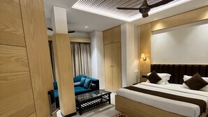 Um quarto moderno com uma cama grande, um sofá e um ventilador de teto.