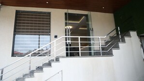 A staircase with metal railings leading to a door with a glass panel. - Hotel sar kamla dham (Mathura)