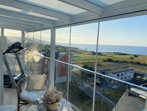 A balcony with a treadmill, a wicker chair, and a potted plant. - LUXURY DUPLEX IN FOZ WITH SEA VIEWS (Foz)