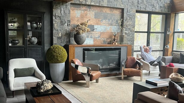 A spacious living room with a stone wall, a fireplace, and modern furniture. - Byarsa Hotel Skardu (Skardu)