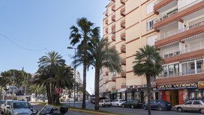 Un edificio a più piani con balconi e una zona commerciale a livello strada.