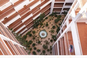 A multi-level atrium with a central circular planter surrounded by potted plants. - GALEON, 10º-75 (ATICO) (Cullera)