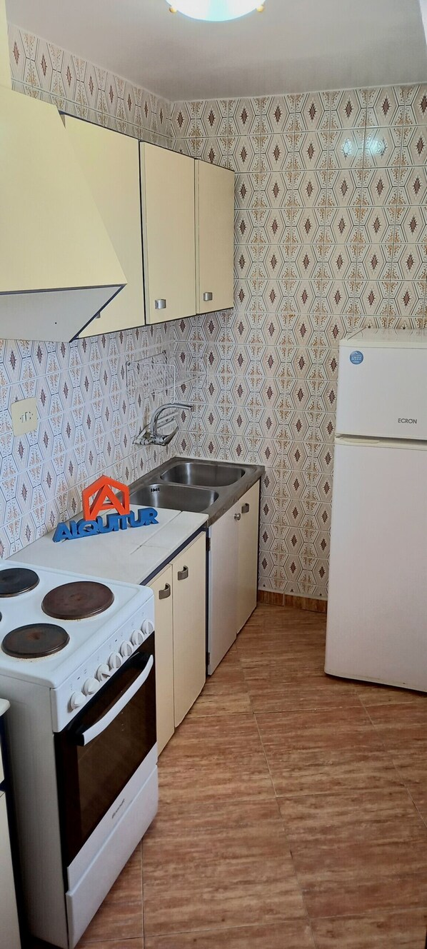 A kitchen with a stove, sink, and refrigerator. - GALEON, 10º-75 (ATICO) (Cullera)