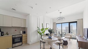 A modern kitchen with a built-in oven and a dining area with a round table and chairs. - Silkhaus Burj Royale, Downtown Dubai (Dubai)
