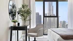 A modern hotel room with a large window, a desk with a lamp, a chair, and a bed. - Silkhaus Burj Royale, Downtown Dubai (Dubai)