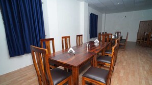 A conference room with a long wooden table, six chairs, and a projector. - Kotri Resort (Jaisalmer)