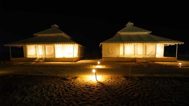 Two illuminated yurts on a sandy surface at night. - Kotri Resort (Jaisalmer)