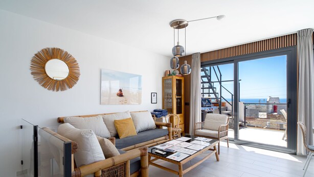 A modern living room with a sofa, armchairs, a coffee table, a large mirror, and a view of the sea through a sliding glass door. - Villa Luxuria Private Pool by Casasol (Nerja)