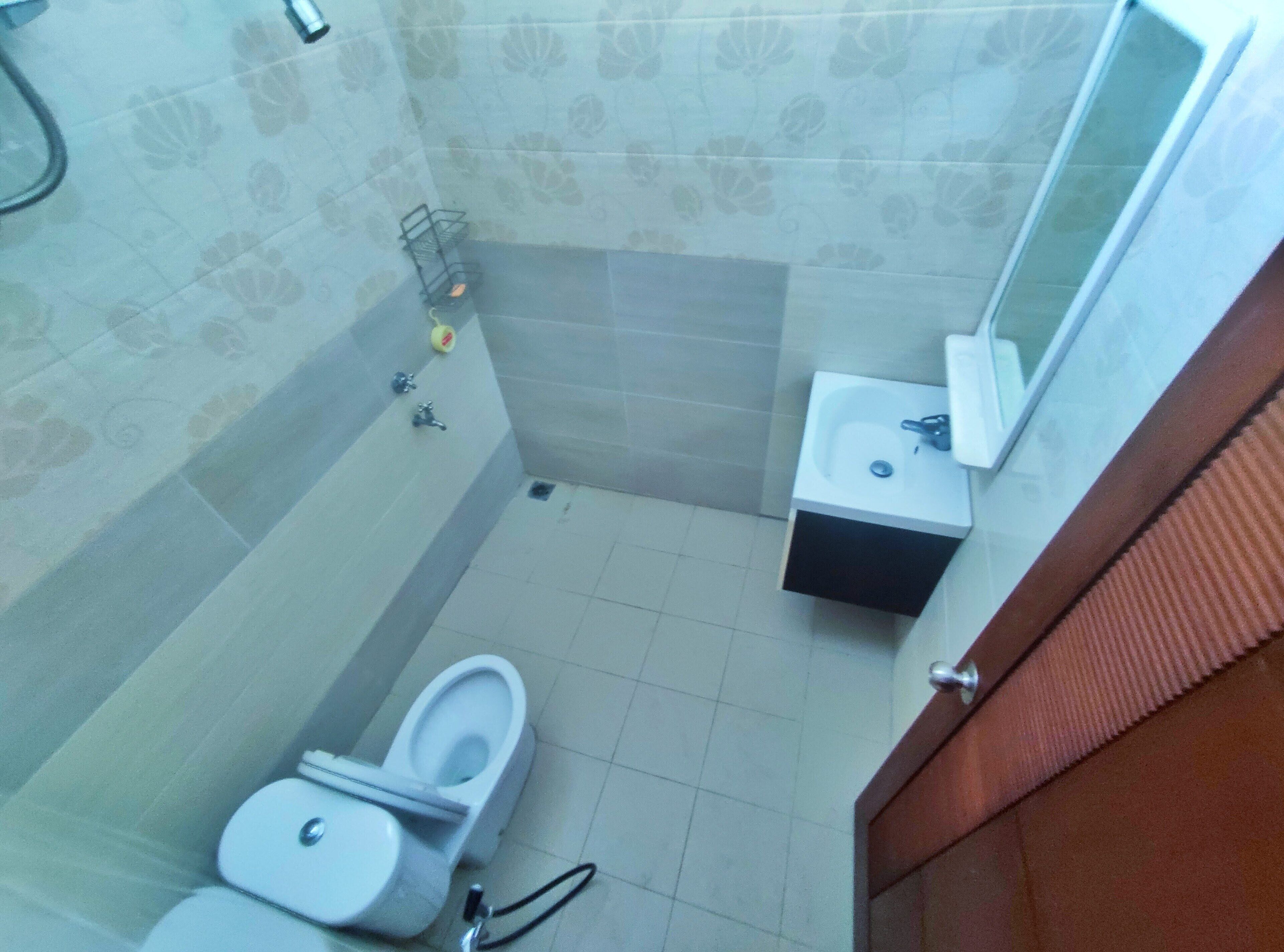 A bathroom with a toilet, sink, and shower area.