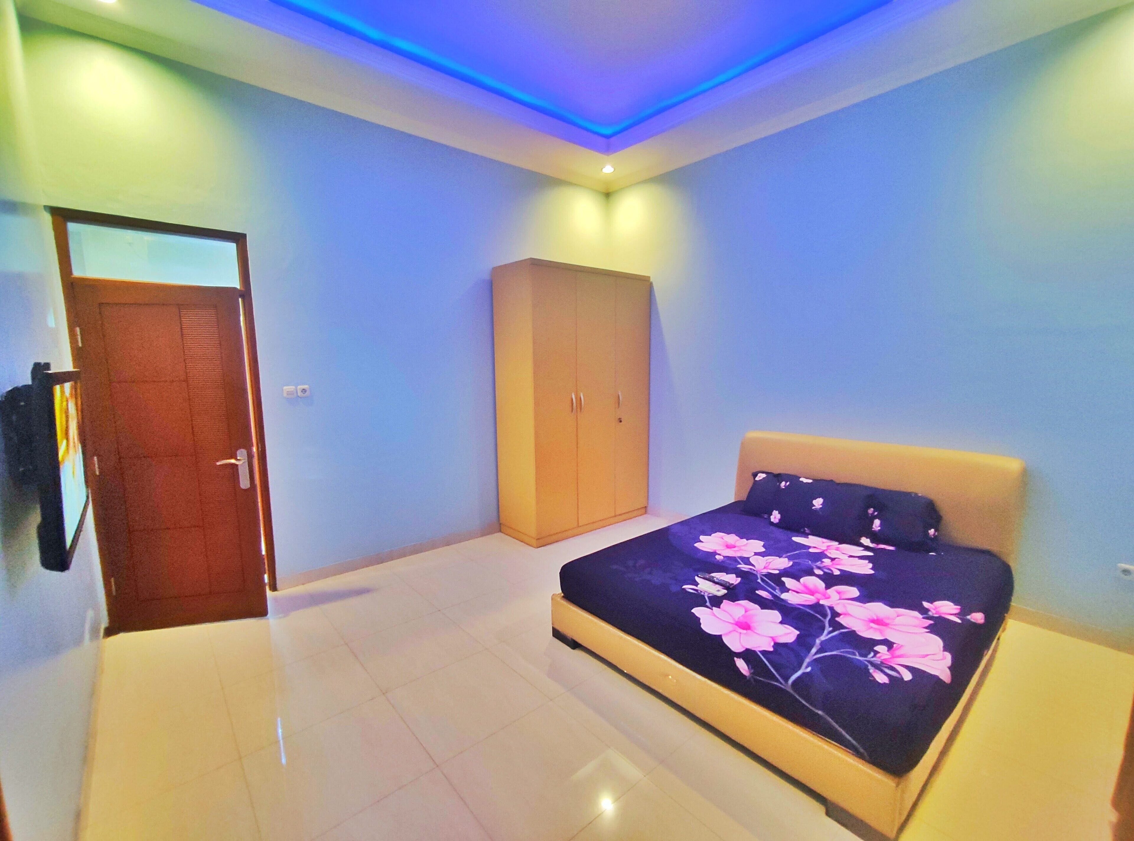 A bedroom with a bed, a wardrobe, and a door.