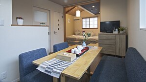A compact living space with a dining area, a sofa, a TV, and a kitchenette. - TokinoyadoNijo (Kyoto)