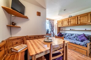 A wooden dining table with chairs, a wooden bench, a sofa, and wooden cabinets. - Apartment 'Nikye Morillon 5 Personnes' with Mountain View and Balcony (Morillon)