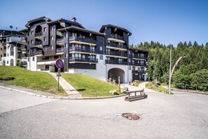 A multi-story hotel with balconies, a no parking sign, and a paved driveway. - Apartment 'Nikye Morillon 5 Personnes' with Mountain View and Balcony (Morillon)