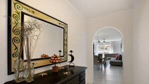 A modern interior with a black console table, decorative mirrors, and a view into a dining area. - Medano Beach Home Ocean View Apartment with Sea Views, Balcony and Wi-Fi (El Medano)