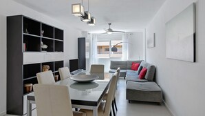 A modern living space with a dining area, a sofa, and a ceiling fan. - Medano Beach Home Ocean View Apartment with Sea Views, Balcony and Wi-Fi (El Medano)