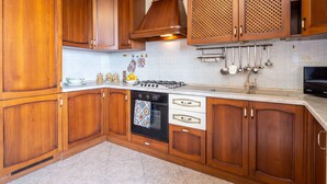 A kitchen with wooden cabinets, a stove, and a microwave.
