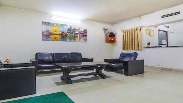 A reception area with a reception desk, a sofa, and a coffee table. - MeroStay 186 Hotel RR (Kathmandu)