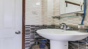 A bathroom with a white sink, a mirror, and a tiled backsplash. - MeroStay 186 Hotel RR (Kathmandu)