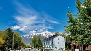 A street with modern buildings, a clear sky, and a mountain in the background. - 3 Bedroom Townhome Suite (Ogden)