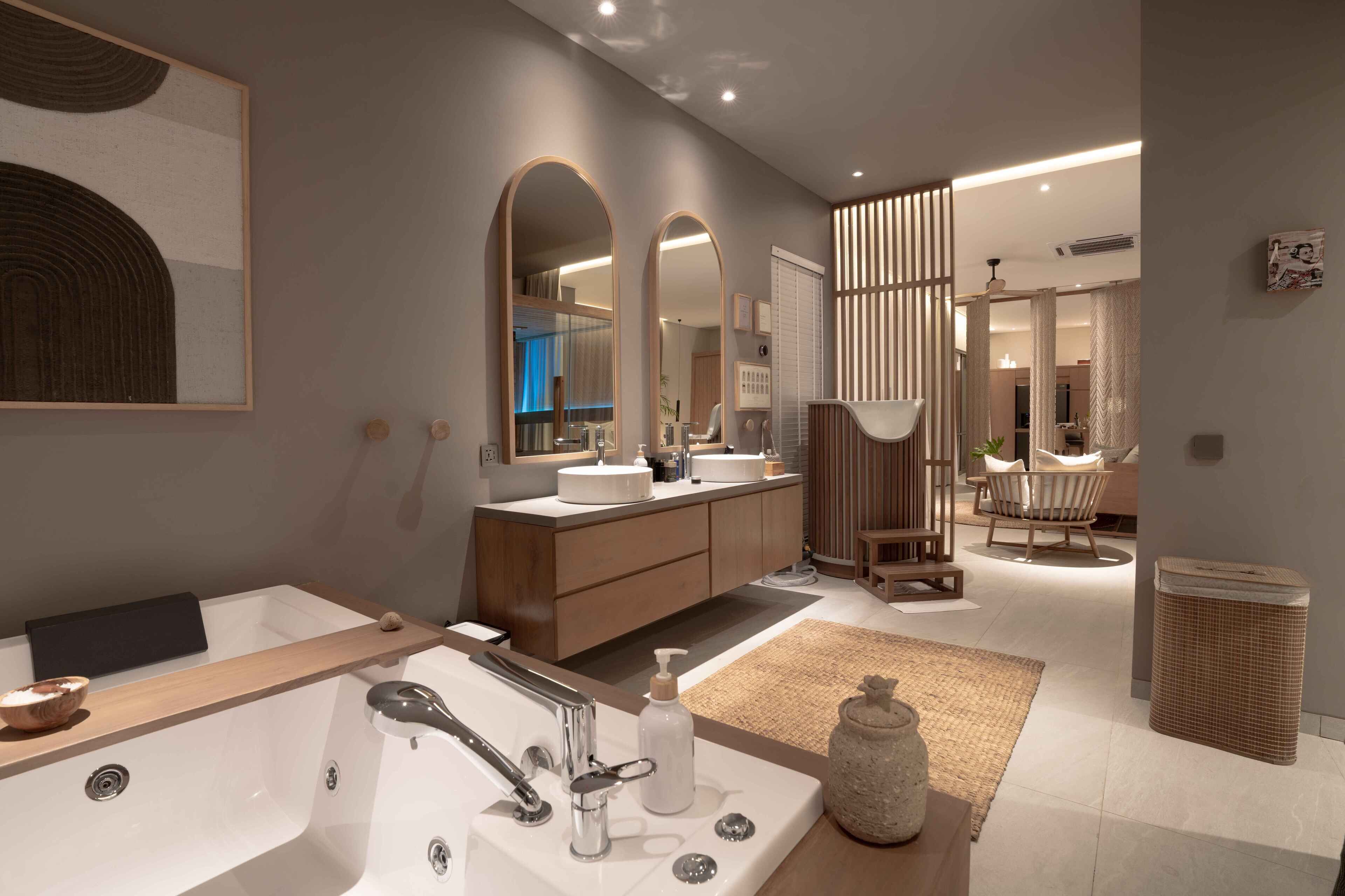 A modern bathroom with a large bathtub, two sinks, and a vanity area.