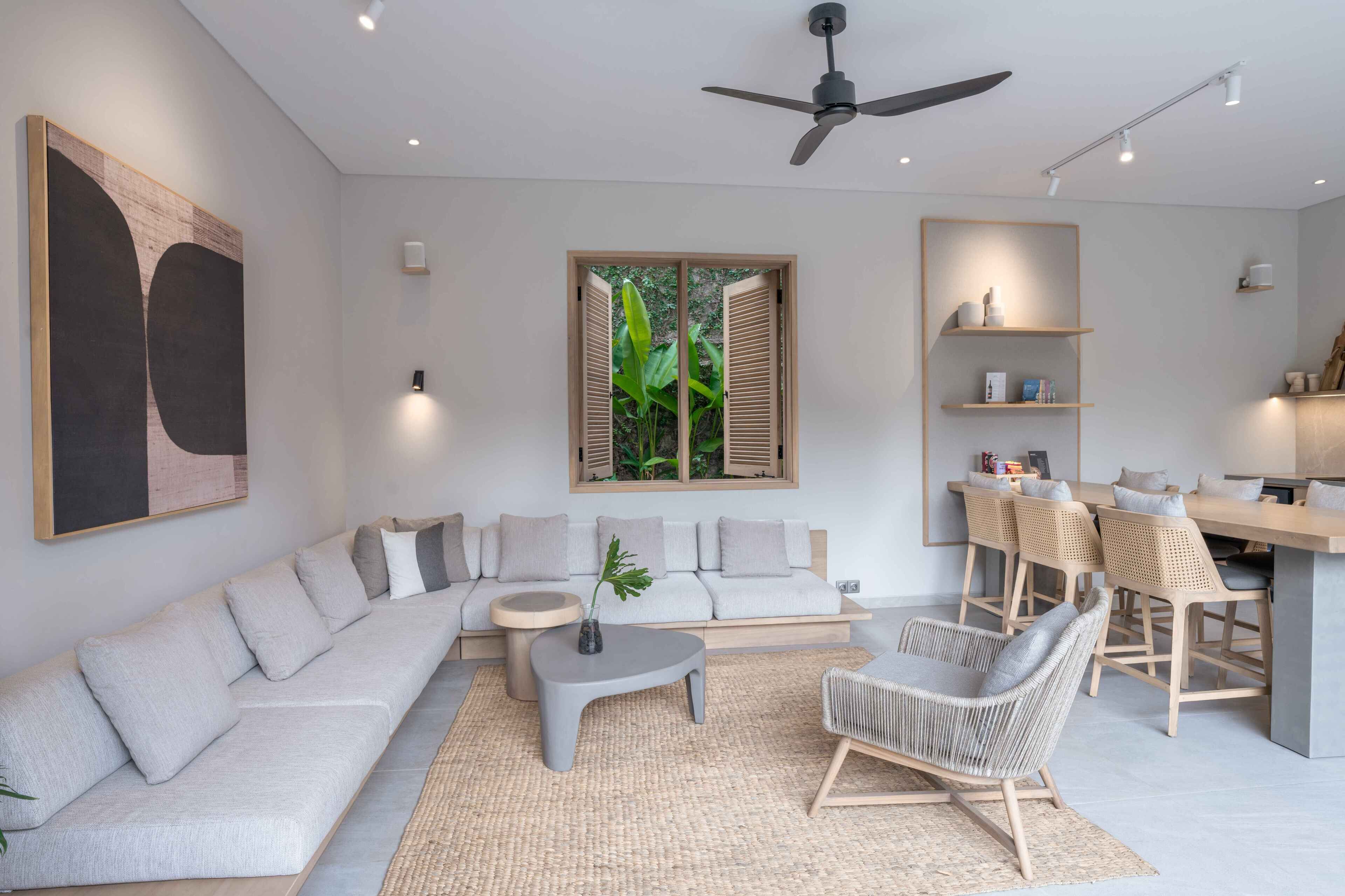 Una sala moderna con un sofá, una mesa de centro y un comedor con sillas y una mesa.