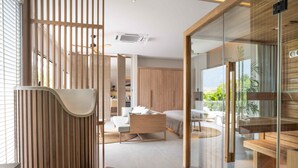 Un interior moderno con un separador de madera, una cama, un sofá y una zona de comedor.