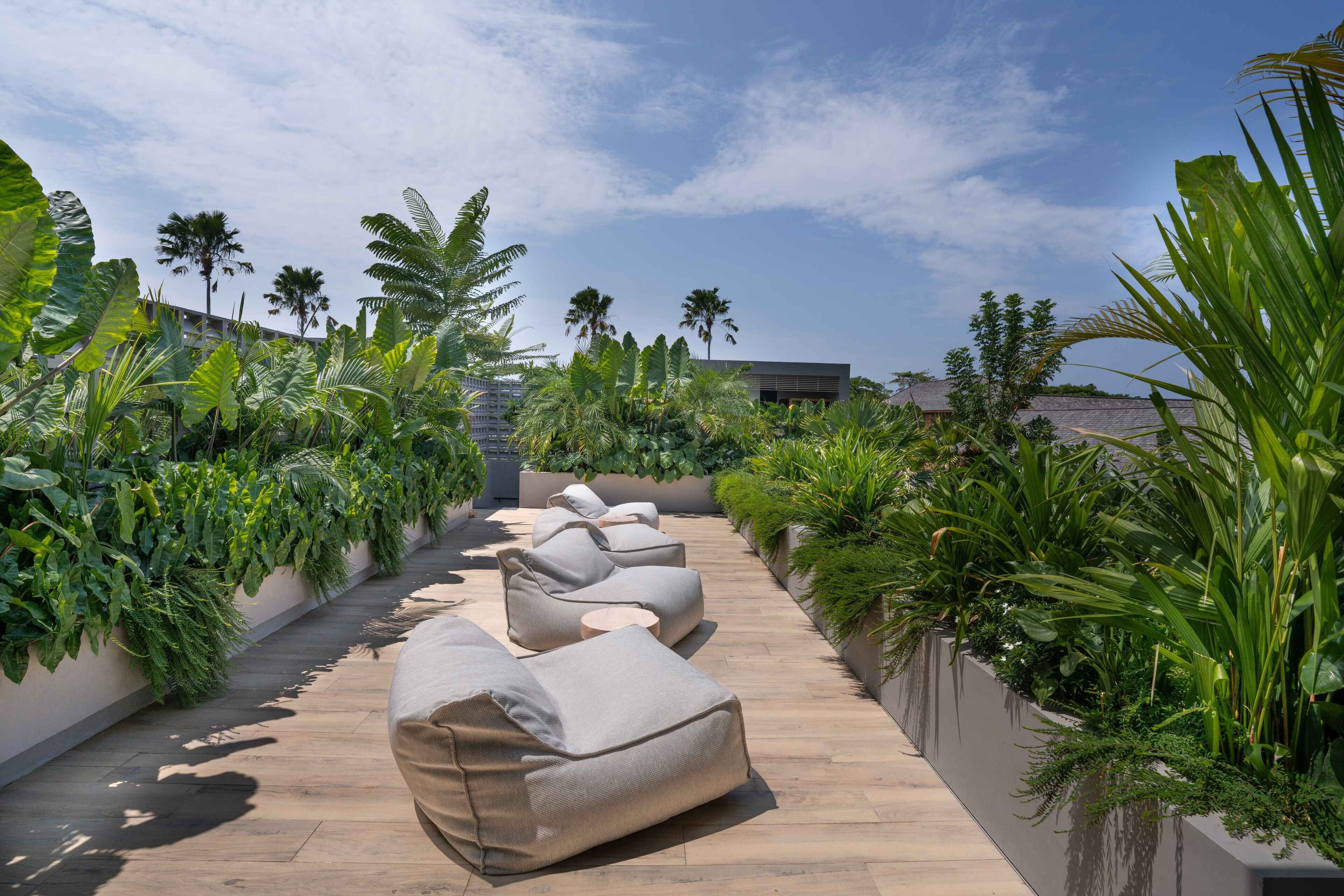 A rooftop lounge area with outdoor seating and lush greenery.
