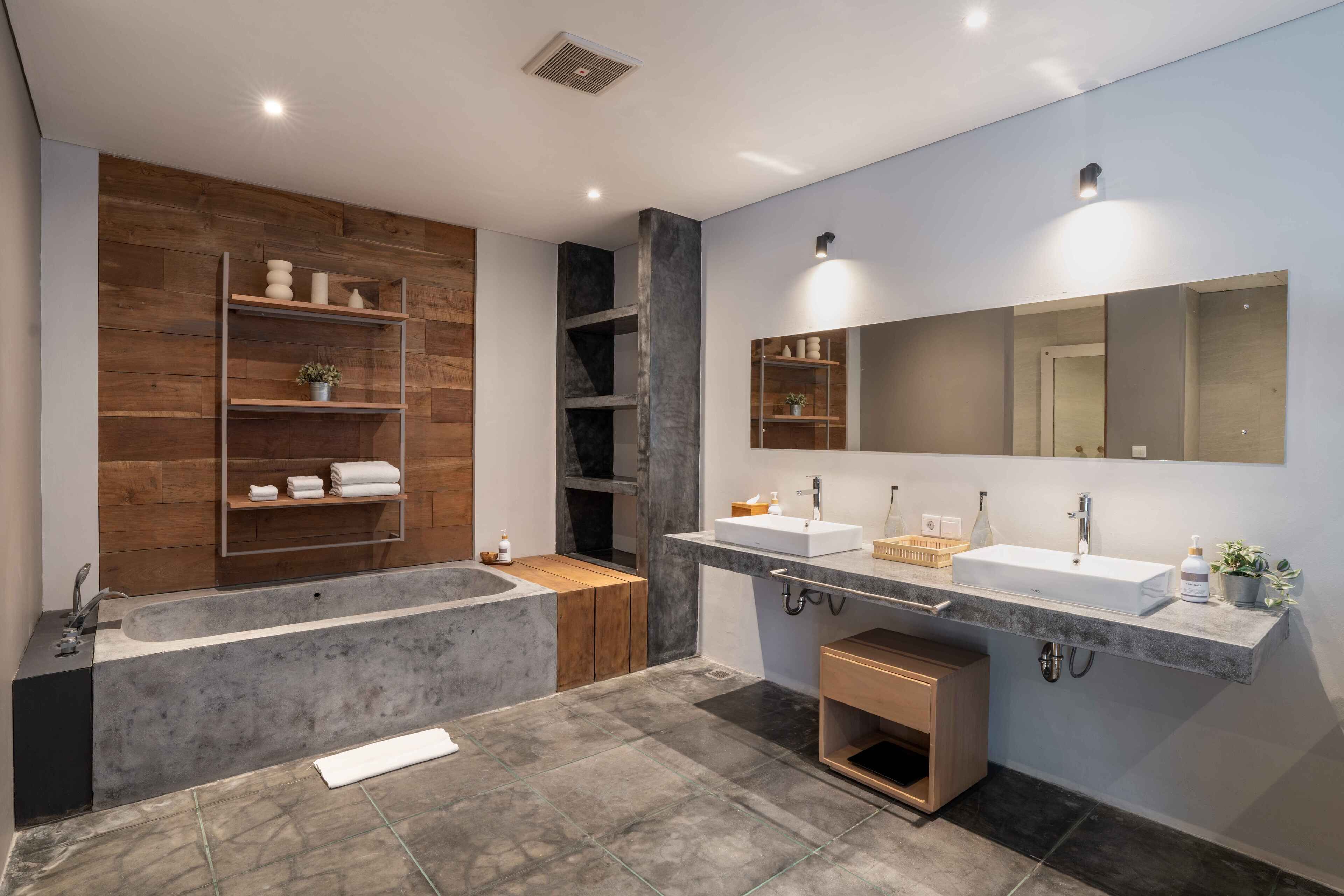 Une salle de bain moderne avec une baignoire sur pieds, deux vasques et des étagères intégrées.