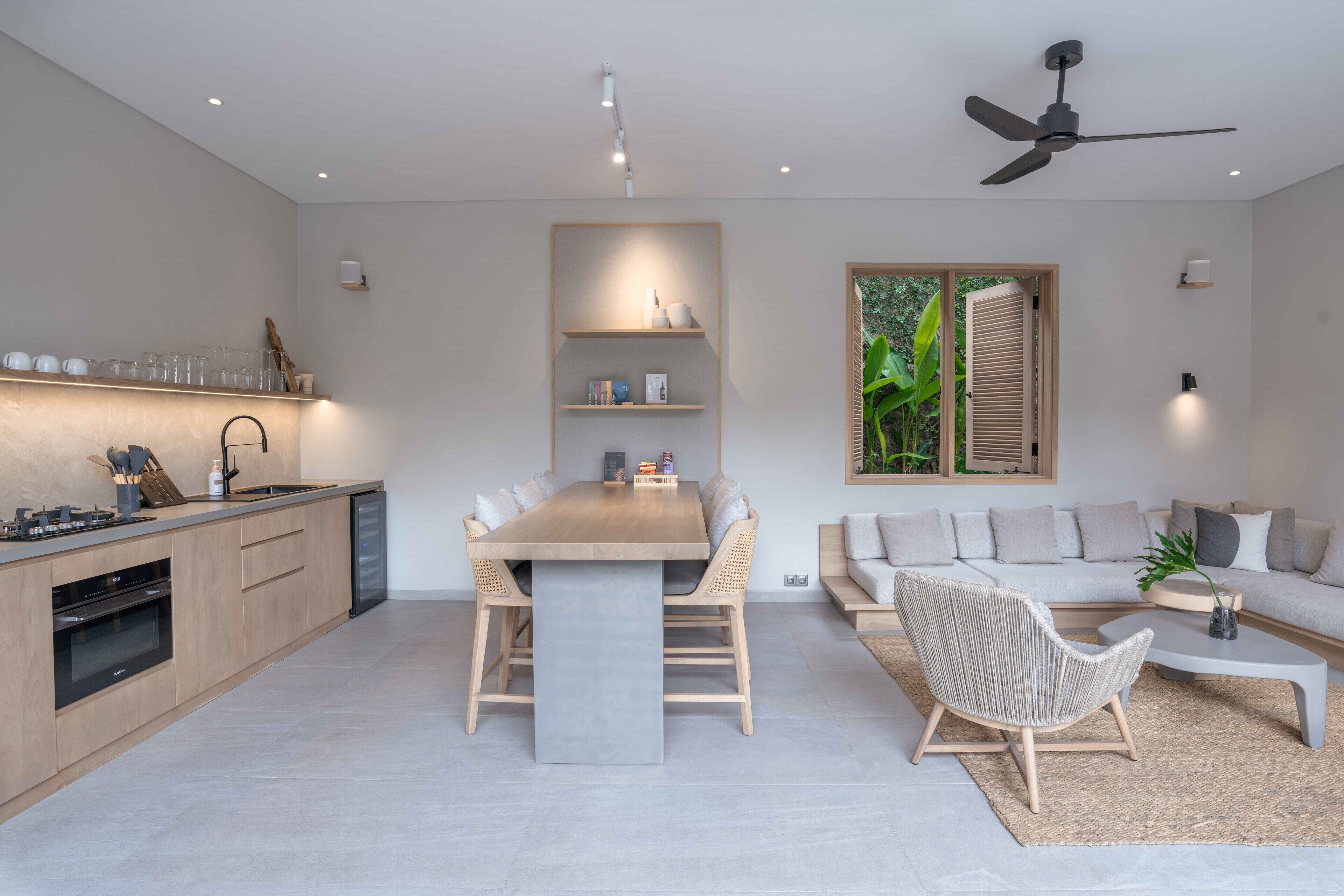 A modern kitchen with a dining area, a sofa, and a coffee table.