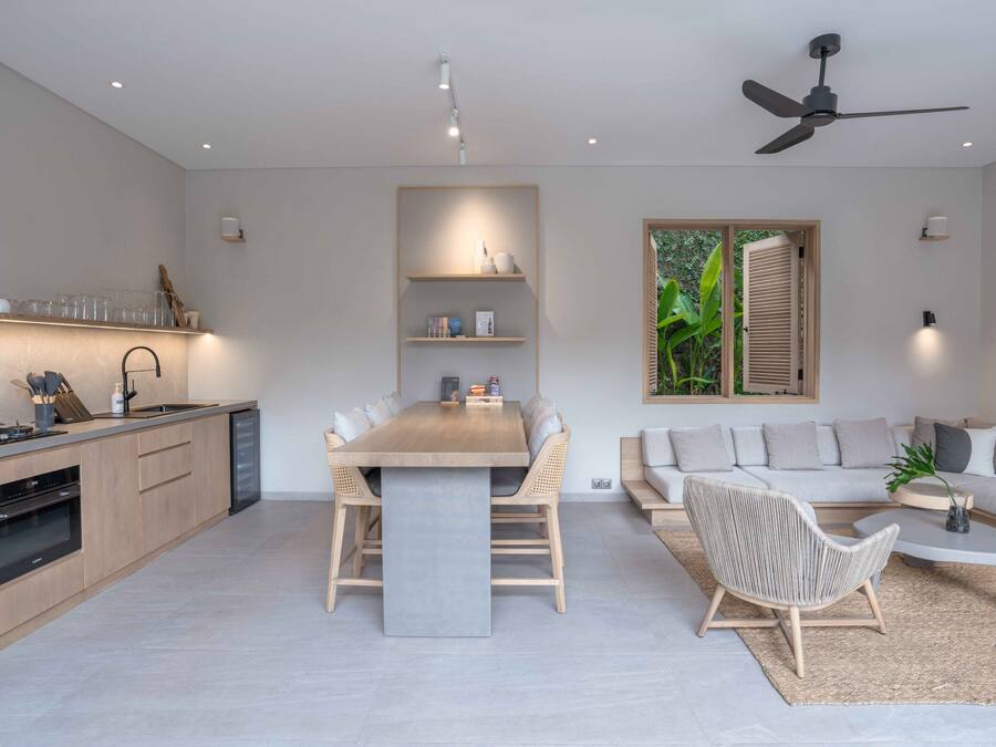 A modern kitchen with a dining area, a sofa, and a coffee table.