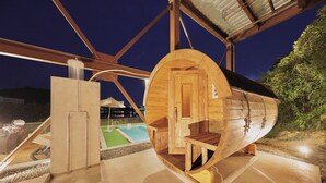 Una cabaña con forma de barco de madera, con piscina y zona de estar al aire libre.