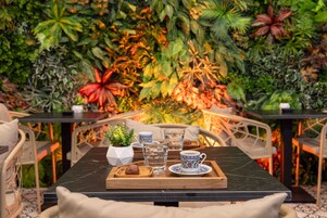 A table with a tray holding a cup, a glass, and a small plant.
