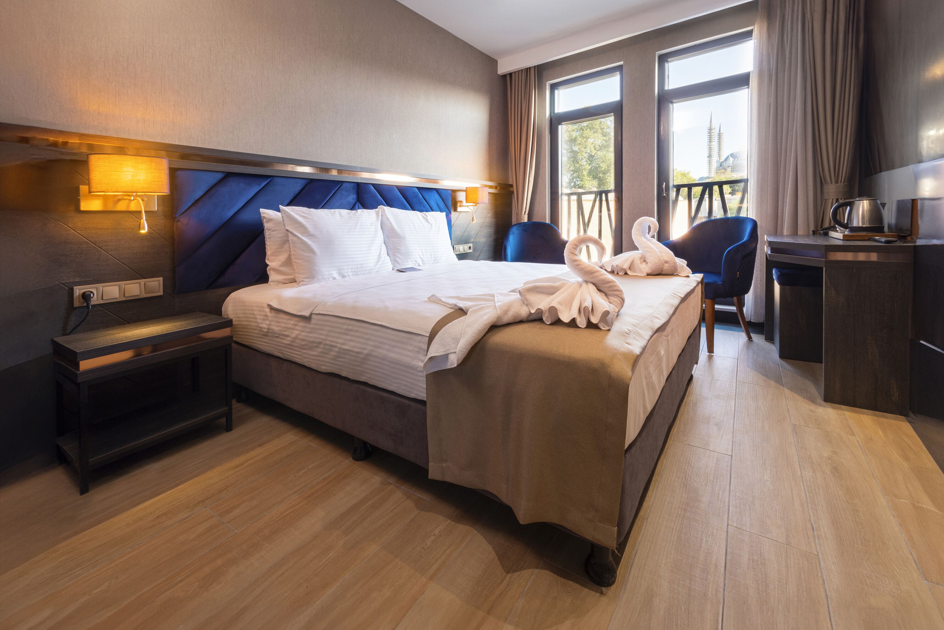 Una habitación de hotel con una cama grande, un escritorio, una silla y un balcón con vistas.