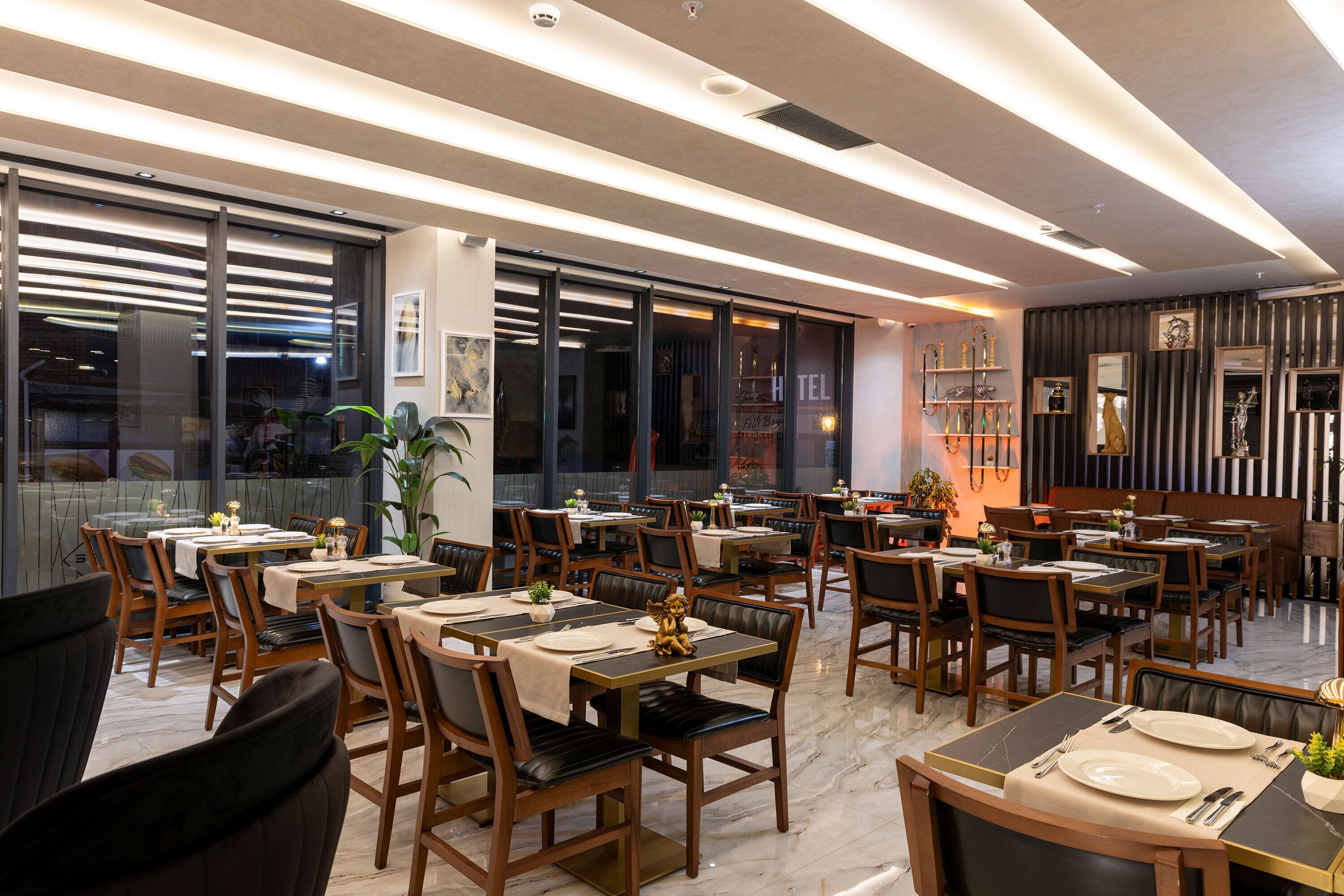 A restaurant with multiple dining tables and chairs, large windows, and a modern interior design.
