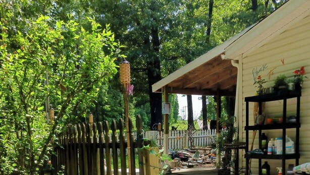 Un bain à remous avec une terrasse en bois et un espace abrité agrémenté de plantes et de mobilier d’extérieur.