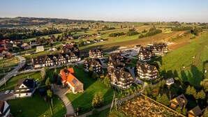 Um bairro residencial com várias casas, ruas e campos verdes.