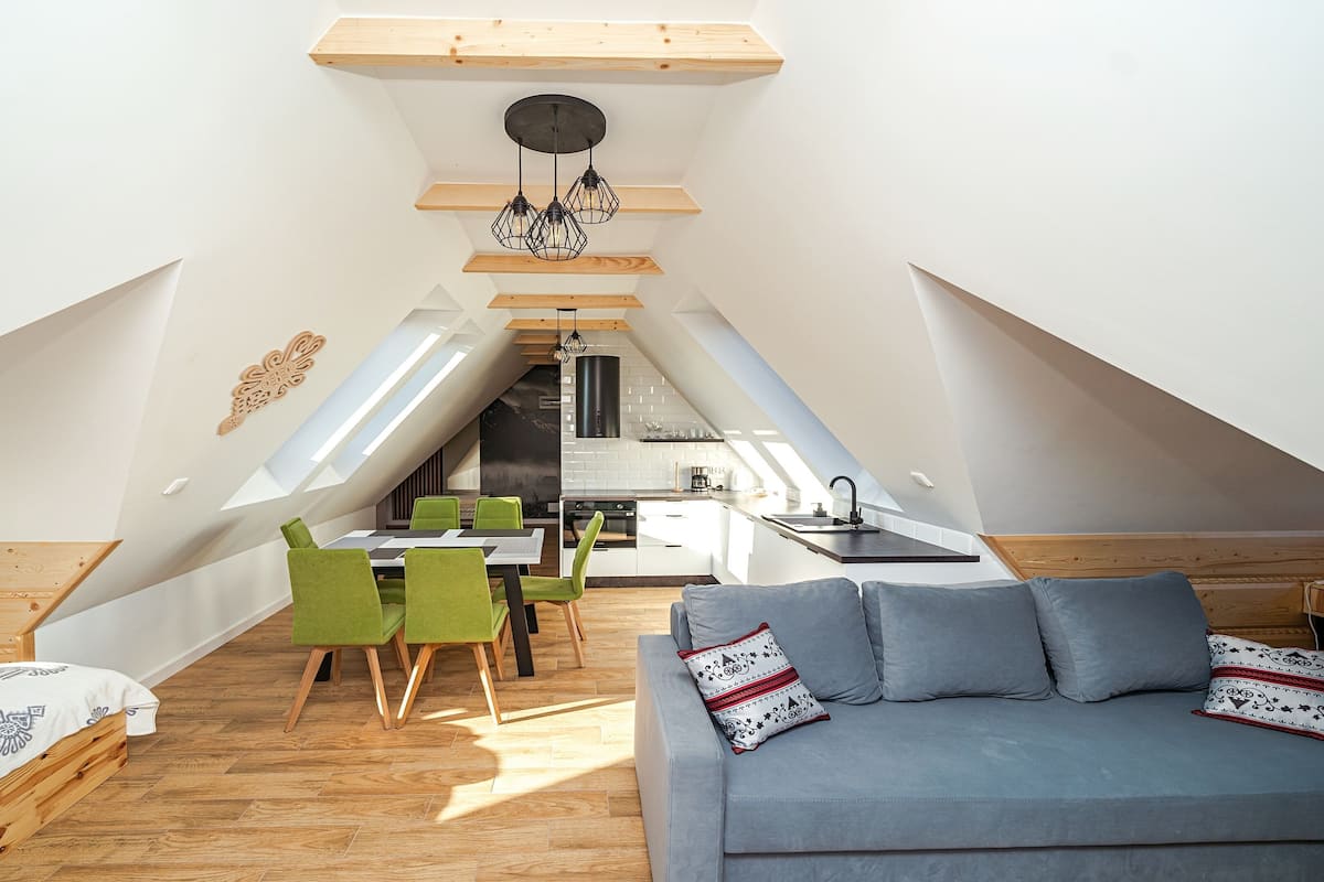 Eine kompakte, moderne Loftswohnung mit Essbereich, Küchenzeile und einer gemütlichen Sitzecke.