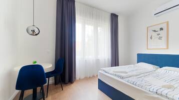 Ein modernes Schlafzimmer mit einem Bett, einem Schreibtisch und Sesseln.