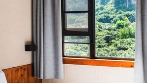 Una ventana con vistas a un follaje exuberante y un marco de madera.