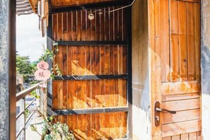 A wooden door with a metal latch and a sign with Japanese characters. - Manman Qingfeng Hostel (Xingyi)