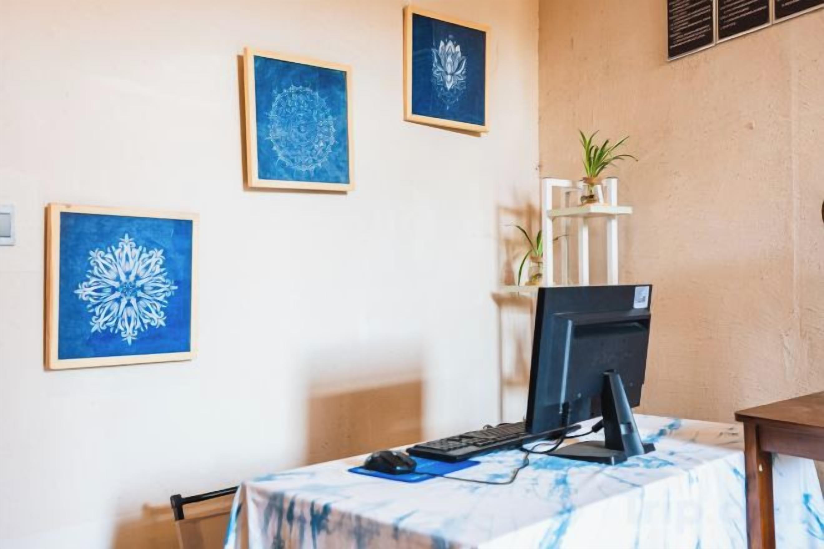 Una habitación con un escritorio, una silla y decoración en la pared.